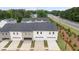 Rear view of townhomes with attached garages, showing proximity to green space and nearby highway at 436 Reflection Dr # 15, Stockbridge, GA 30281