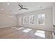 Spacious living room featuring hardwood floors, recessed lights, ceiling fan, and large windows at 4667 Larkfield Way, Powder Springs, GA 30127