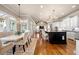 Bright kitchen featuring a large island with barstool seating, white cabinets, hardwood floors, and elegant chandeliers at 5120 Parkwood Oaks Ln, Smyrna, GA 30126