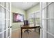 Cozy home office with French doors, a large window, and a classic wooden desk and chair at 5120 Parkwood Oaks Ln, Smyrna, GA 30126