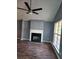 Living room with a cozy fireplace and modern ceiling fan at 5778 Eagles Feather Ln, Riverdale, GA 30274