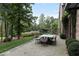 Backyard featuring an outdoor dining area surrounded by mature trees and manicured landscaping at 7455 Old Rico Rd, Chattahoochee Hills, GA 30268