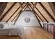 Unique bedroom features a circular window, exposed beams, hardwood floors, and elegant decor at 7455 Old Rico Rd, Chattahoochee Hills, GA 30268