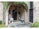Covered stone entryway with arched brick detail and stylish lighting fixtures at 7455 Old Rico Rd, Chattahoochee Hills, GA 30268