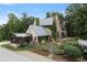 Beautiful exterior of a brick home showcasing a greenhouse, garden, and mature landscaping at 7455 Old Rico Rd, Chattahoochee Hills, GA 30268