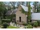 Charming stone home with metal roof, ivy-covered walls, and lush garden at 7455 Old Rico Rd, Chattahoochee Hills, GA 30268