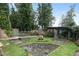 Charming garden with raised beds, wooden fence, and an inviting stone walkway surrounded by lush greenery at 7455 Old Rico Rd, Chattahoochee Hills, GA 30268