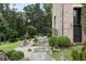 Stone path leading to a brick home with a cozy seating area and lush greenery at 7455 Old Rico Rd, Chattahoochee Hills, GA 30268