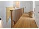 Hallway with light wood floors, rustic railing, and a decorative blanket at 7455 Old Rico Rd, Chattahoochee Hills, GA 30268