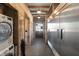 Bright hallway featuring a full laundry and a stainless steel refrigerator at 7455 Old Rico Rd, Chattahoochee Hills, GA 30268