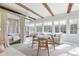 Sun-filled living room with exposed beams, a sitting area, and ample windows with scenic views at 7455 Old Rico Rd, Chattahoochee Hills, GA 30268
