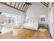 Spacious main bedroom boasts vaulted ceilings, wood floors, and oversized windows showcasing beautiful views at 7455 Old Rico Rd, Chattahoochee Hills, GA 30268
