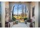 Covered brick patio with comfortable wicker seating and views of the expansive lawn at 7455 Old Rico Rd, Chattahoochee Hills, GA 30268