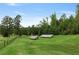 Expansive green field featuring solar panels, surrounded by mature trees, creating a sustainable landscape at 7455 Old Rico Rd, Chattahoochee Hills, GA 30268