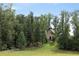 Picturesque view of a well-manicured lawn leading up to a brick home, framed by mature trees at 7455 Old Rico Rd, Chattahoochee Hills, GA 30268