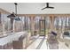 Inviting sunroom with comfortable seating, a ceiling fan, and scenic outdoor views through arched windows at 7455 Old Rico Rd, Chattahoochee Hills, GA 30268
