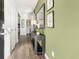 Inviting entryway with wood floors, olive walls, decorative mirror, console table, and white doors at 121 Oakchase Park Lane, Hampton, GA 30228