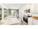 Well-lit kitchen with white cabinets, stainless steel appliances, and a dining area at 121 Oakchase Park Lane, Hampton, GA 30228