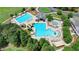 Aerial view of the community pool with slides, multiple pools and a clubhouse amid mature trees providing a resort-like setting at 3305 Suffolk Dr, Cumming, GA 30041
