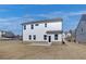 Two-story house with vinyl siding, multiple windows, and a small concrete patio in the backyard at 3941 Adler Cir, Buford, GA 30519