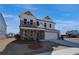 Two-story home with brick and white siding, charming covered porch with detailed wood supports, and a two-car garage at 3941 Adler Cir, Buford, GA 30519