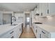 Galley kitchen has white cabinets, stainless appliances, and quartz counters at 3941 Adler Cir, Buford, GA 30519