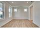 Well-lit living room with wood floors, multiple windows, and neutral paint creating a blank canvas at 3941 Adler Cir, Buford, GA 30519