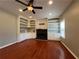 Spacious living room with hardwood floors, fireplace, built-in shelving, and ceiling fan at 3954 Lullwater Main Nw, Kennesaw, GA 30144