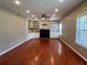 Open living room with hardwood floors, fireplace, built-in shelving, and ceiling fan at 3954 Lullwater Main Nw, Kennesaw, GA 30144