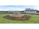 A stone water feature is set in the middle of a manicured lawn in front of townhomes at 448 Reflection Dr # 18, Stockbridge, GA 30281