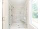 Modern bathroom featuring a frameless glass shower, white marble tile, and a built-in bench at 4671 Larkfield Way, Powder Springs, GA 30127