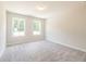 An empty room with neutral carpet and light gray walls featuring two windows to the outdoors at 4671 Larkfield Way, Powder Springs, GA 30127