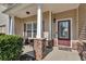 Inviting front porch featuring stone supports, neutral siding, and a stylish entry door, perfect for relaxing outdoors at 1531 Autumn Wood Trl, Buford, GA 30518