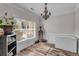Bright home office space with wood-look floors, chandelier, large window, and crisp white trim at 1531 Autumn Wood Trl, Buford, GA 30518