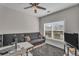 Comfortable home office featuring a gray sofa, ceiling fan, and natural light, ideal for remote work or study at 1531 Autumn Wood Trl, Buford, GA 30518