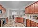 Open kitchen featuring stainless steel appliances, wood cabinets, tile backsplash, and a view into the dining area at 1531 Autumn Wood Trl, Buford, GA 30518