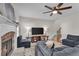 Cozy living room boasts a stone fireplace, wood look floors, a ceiling fan, and plush seating at 1531 Autumn Wood Trl, Buford, GA 30518