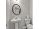 Well-lit powder room with pedestal sink and toilet at 1531 Autumn Wood Trl, Buford, GA 30518
