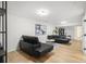 Finished basement living room with sleek black sofas and wood-look flooring at 3388 Hyland Dr, Decatur, GA 30032