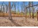 A backyard enclosed by a wooden fence and adorned with mature trees at 6739 Valley Ct, Douglasville, GA 30135