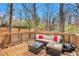 Deck with outdoor seating, pillows, and beautiful wooded backdrop at 6739 Valley Ct, Douglasville, GA 30135