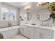 Modern bathroom featuring a double vanity, soaking tub, and elegant lighting fixtures at 215 Arizona Ne Ave # 1, Atlanta, GA 30307