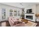 Cozy living room with a fireplace, large windows, and a comfortable pink sectional at 215 Arizona Ne Ave # 1, Atlanta, GA 30307
