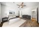 Bedroom with wood-look floors, neutral walls, ceiling fan, and furnished with bed and side tables at 3435 Stallion Ct, Powder Springs, GA 30127