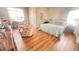 Bright bedroom featuring wood floors, a large bed, and a sitting area with floral chairs at 70 Trelawney Cir, Covington, GA 30016