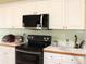 Kitchen featuring an electric range, a built-in microwave, and white cabinets at 70 Trelawney Cir, Covington, GA 30016