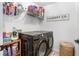 Well-organized laundry room with modern black appliances, shelving, and a decorative laundry sign at 113 Windsong Trl, Canton, GA 30114