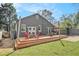 A backyard featuring a spacious wooden deck with outdoor seating surrounded by lush green grass under a blue sky at 1552 Newton Se Ave, Atlanta, GA 30316