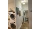 Efficiently designed hallway with stacked washer/dryer and mirror reflecting the kitchen and artwork at 3060 Pharr Court North Nw # 306, Atlanta, GA 30305