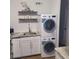 In-unit stacked washer and dryer, above white cabinets and granite countertops at 3060 Pharr Court North Nw # 306, Atlanta, GA 30305